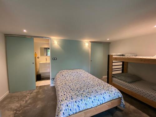 a bedroom with a bunk bed and a mirror at Le Préau : charmante maison au bord de l’Isère in Bourg-de-Péage