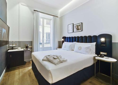 een slaapkamer met een groot bed met witte lakens bij Casa Alberola Alicante, Curio Collection By Hilton in Alicante