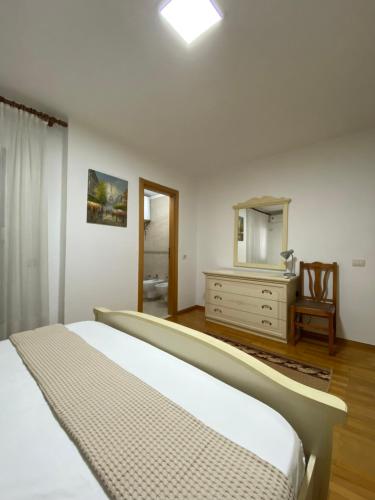 um quarto com uma cama, uma cómoda e um espelho em Premier by Broci Apartments em Tirana