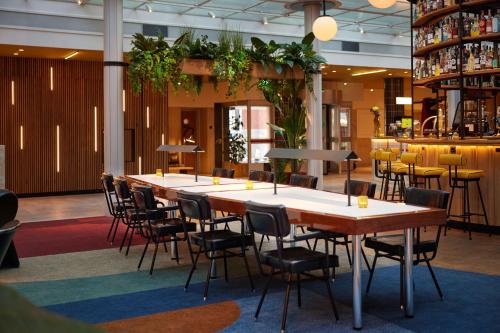 a group of tables and chairs in a room at Motto By Hilton Rotterdam Blaak in Rotterdam