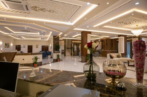 a hotel lobby with a counter with a vase of flowers at نسيم الشفا للشقق الفندقية in Taif