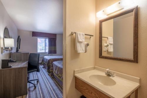 ein Hotelzimmer mit einem Waschbecken und einem Bett in der Unterkunft Super 8 by Wyndham Butte MT in Butte