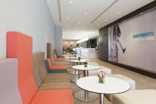 a row of tables and chairs in a restaurant at Hampton By Hilton Rome East in Rome