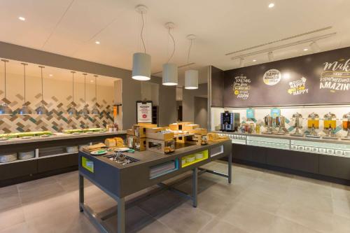 a restaurant with a counter with food on it at Hampton By Hilton Rome East in Rome