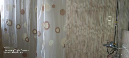 a bathroom with a shower with a shower curtain at HARRIET APARTHOTEL Kigali-NYARUTARAMA in Kigali
