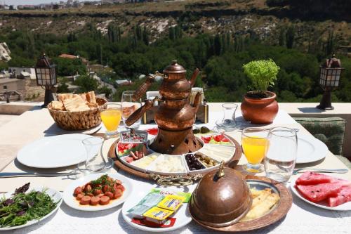 a table full of food with a view of a mountain at Cappadocia Nar Cave House & Swimming Pool in Nevsehir