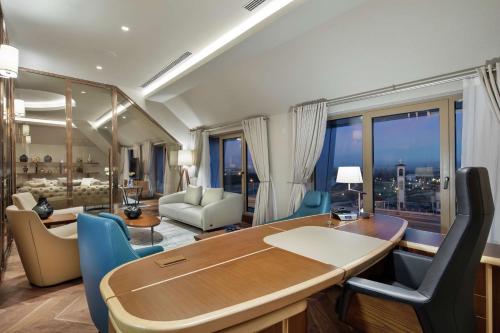 a dining room with a table and chairs and a living room at DoubleTree By Hilton Skopje in Skopje