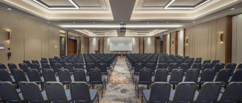 a conference room with chairs and a projection screen at DoubleTree By Hilton Skopje in Skopje