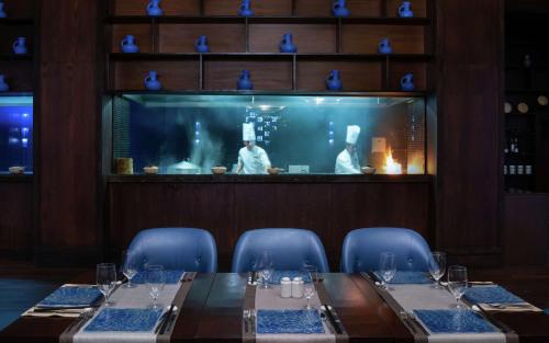 a dining room with a table and chairs and a chef at Hilton Dushanbe in Dushanbe