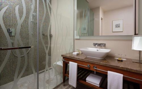 a bathroom with a sink and a shower at Hilton Dushanbe in Dushanbe