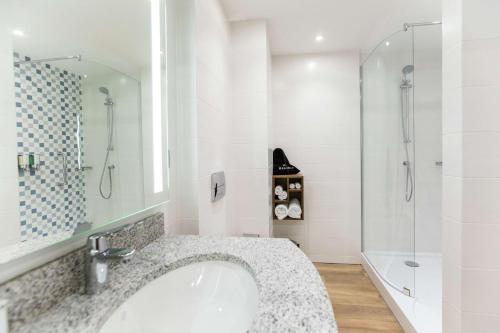 y baño con lavabo y ducha. en Hampton by Hilton Brest, en Brest