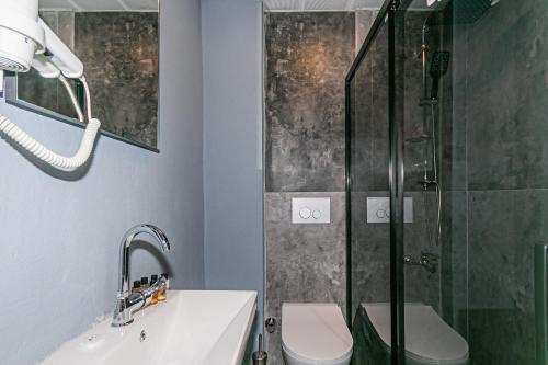 uma casa de banho com um chuveiro, um WC e um lavatório. em Lara World Hotel em Antalya