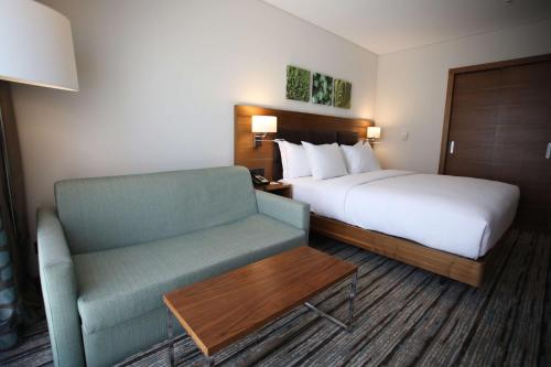 アンカラにあるHilton Garden Inn Ankara Gimatのベッドと椅子付きのホテルルーム