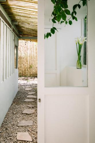 a door leading into a hallway with a vase of flowers at Anzan Atitlan in San Marcos La Laguna