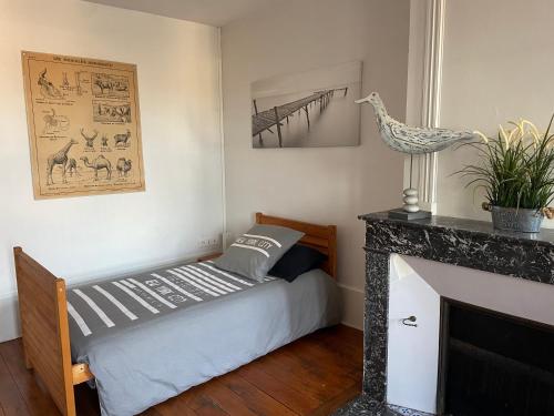 a bedroom with a bed and a fireplace at Grand appartement centre ville quartier calme in Neufchâteau