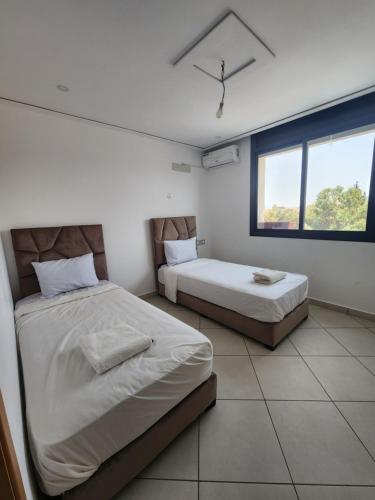 a bedroom with two beds and a window at Familyconfort oujda in Oujda