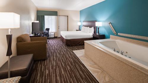 a hotel room with a bed and a bath tub at Best Western Galena Inn & Suites in Galena