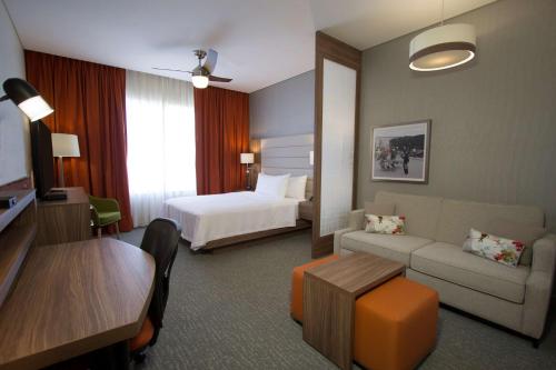 a hotel room with a bed and a living room at Homewood Suites By Hilton Silao Airport in Silao