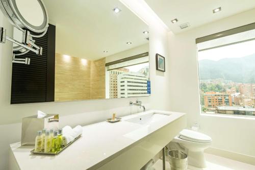 a bathroom with a sink and a toilet and a mirror at Hilton Bogotá in Bogotá