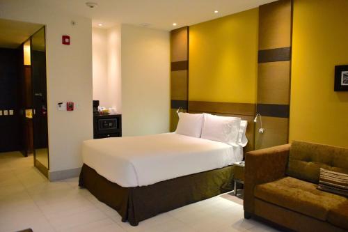 a hotel room with a bed and a chair at Hampton Inn by Hilton Ciudad del Carmen in Ciudad del Carmen