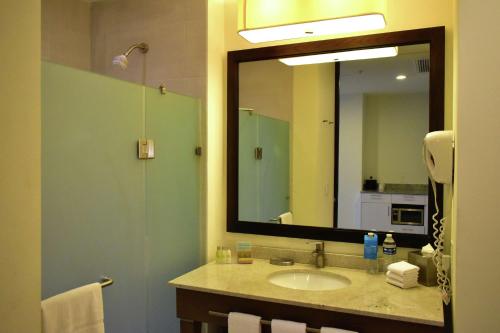 baño con lavabo y espejo grande en Hampton Inn by Hilton Ciudad del Carmen en Ciudad del Carmen