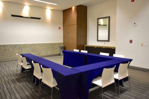 a blue table and white chairs in a room at Hampton Inn by Hilton Ciudad del Carmen in Ciudad del Carmen