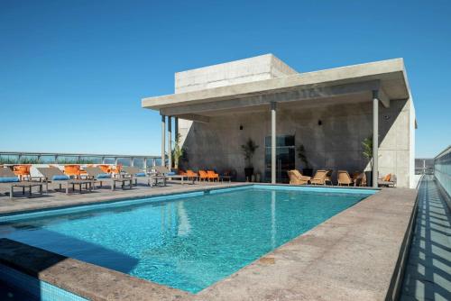 a swimming pool on the roof of a building with a house at Hilton Garden Inn Chihuahua in Chihuahua