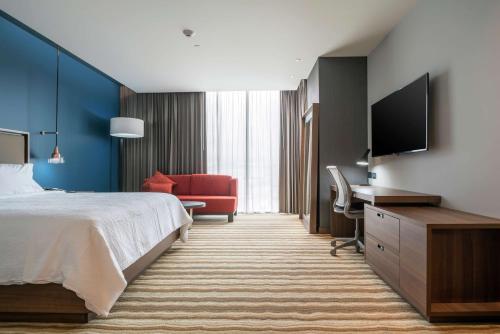 a hotel room with a bed and a flat screen tv at Hilton Garden Inn Chihuahua in Chihuahua
