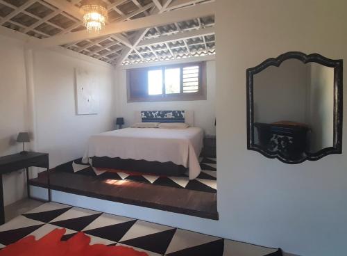 Kite & Sol Beach House Taiba في تايبا: غرفة نوم مع سرير ومرآة على الحائط