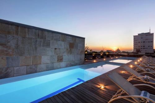 a swimming pool on top of a building with a sunset at Hilton Mexico City Reforma in Mexico City