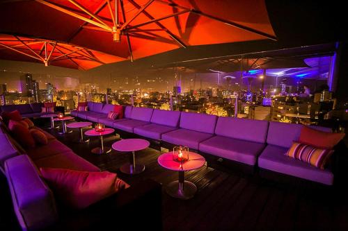 a bar with purple couches and tables with a city skyline at Hilton Lima Miraflores in Lima