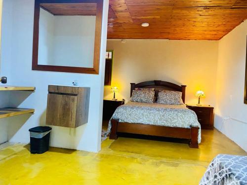 a bedroom with a bed and a wooden ceiling at FINCA HOTEL EL LAUREL - Parque del Café in Montenegro