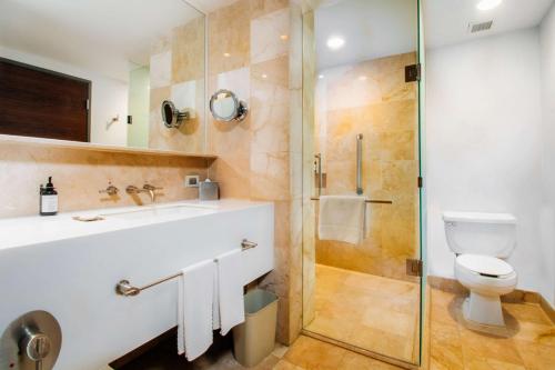 ein Bad mit einem WC und einer Glasdusche in der Unterkunft Doubletree By Hilton Mexico City Santa Fe in Mexiko-Stadt