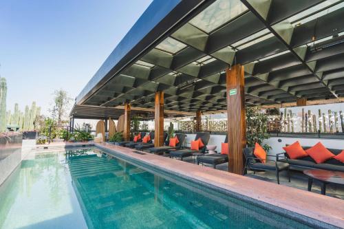 a pool at a hotel with chairs and a patio at Umbral, Curio Collection By Hilton in Mexico City