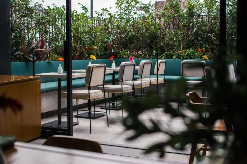 a row of chairs and tables on a patio at Umbral, Curio Collection By Hilton in Mexico City