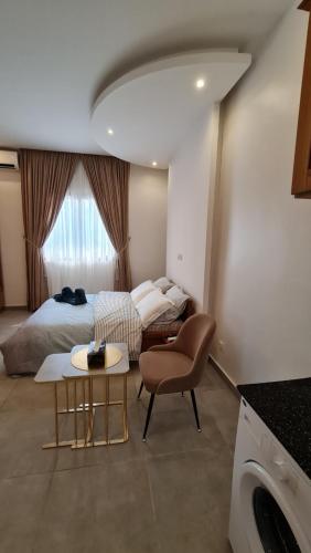 a bedroom with a bed and a table and a chair at KBK Lodge in Abaga