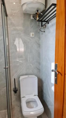 a bathroom with a white toilet in a room at KBK Lodge in Abaga