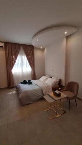 a bedroom with a bed and a table and a window at KBK Lodge in Abaga