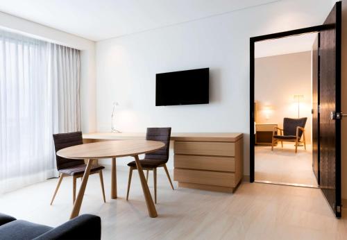 a room with a table and chairs and a mirror at Hilton Garden Inn Merida in Mérida