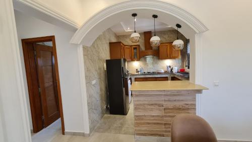 a kitchen with a black refrigerator and wooden cabinets at KBK Lodge in Abaga