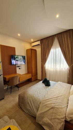 a hotel room with a bed and a desk and a television at KBK Lodge in Abaga