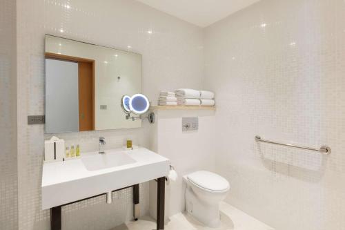 y baño con lavabo, aseo y espejo. en DoubleTree by Hilton Mazatlan, SIN, en Mazatlán