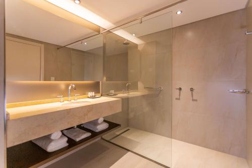 łazienka z 2 umywalkami i prysznicem w obiekcie Hilton Garden Inn Neuquen w mieście Neuquén