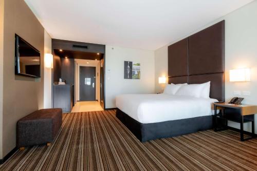 a hotel room with a large bed and a desk at Hilton Garden Inn Neuquen in Neuquén