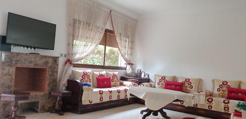 sala de estar con sofá y chimenea en amicale ilyass beach sidi rhal, en Dar Hamida