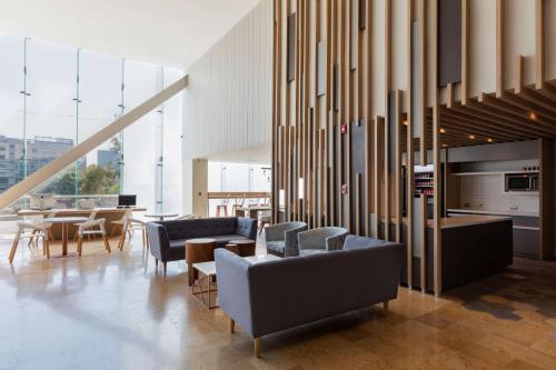 a living room with couches and chairs and tables at Hilton Garden Inn Mexico City Santa Fe in Mexico City