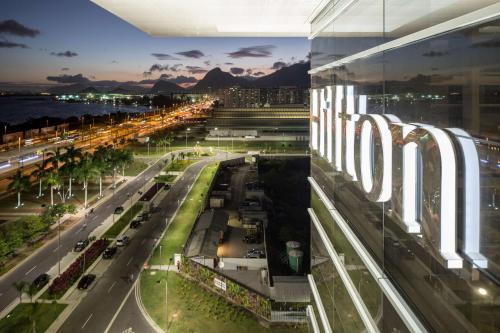 uma cidade com um grande sinal no lado de um edifício em Hilton Barra Rio de Janeiro no Rio de Janeiro