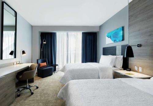 ein Hotelzimmer mit 2 Betten und einem Schreibtisch in der Unterkunft Hilton Garden Inn Mexico City Santa Fe in Mexiko-Stadt