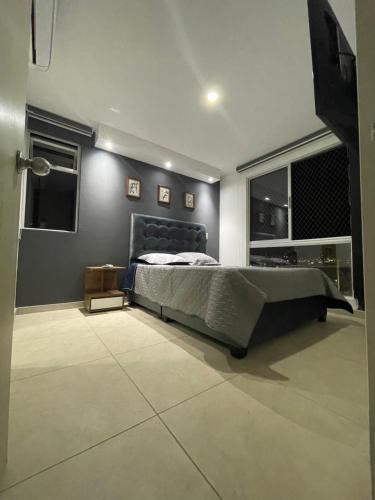 a bedroom with a bed and a large window at Hermoso apto zona sur CALI in Cali