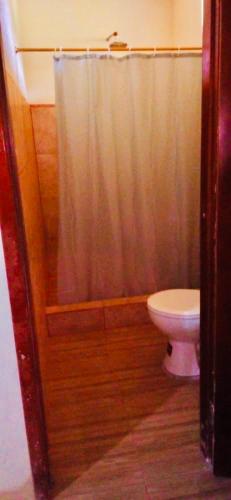 a bathroom with a shower curtain and a toilet at Candurumy Lodge in Tena